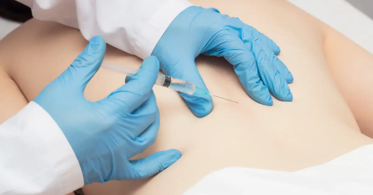 Doctor administering a caudal epidural steroid injection into a patient's lower back in Sandy, UT